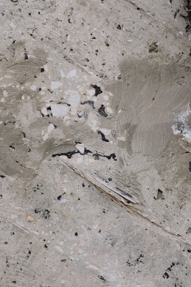 Close up of a worn concrete surface with exposed aggregate and pitting