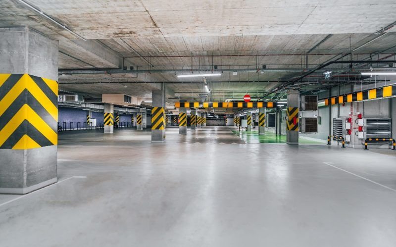 Bare concrete floor slab in a parking structure with painted columns